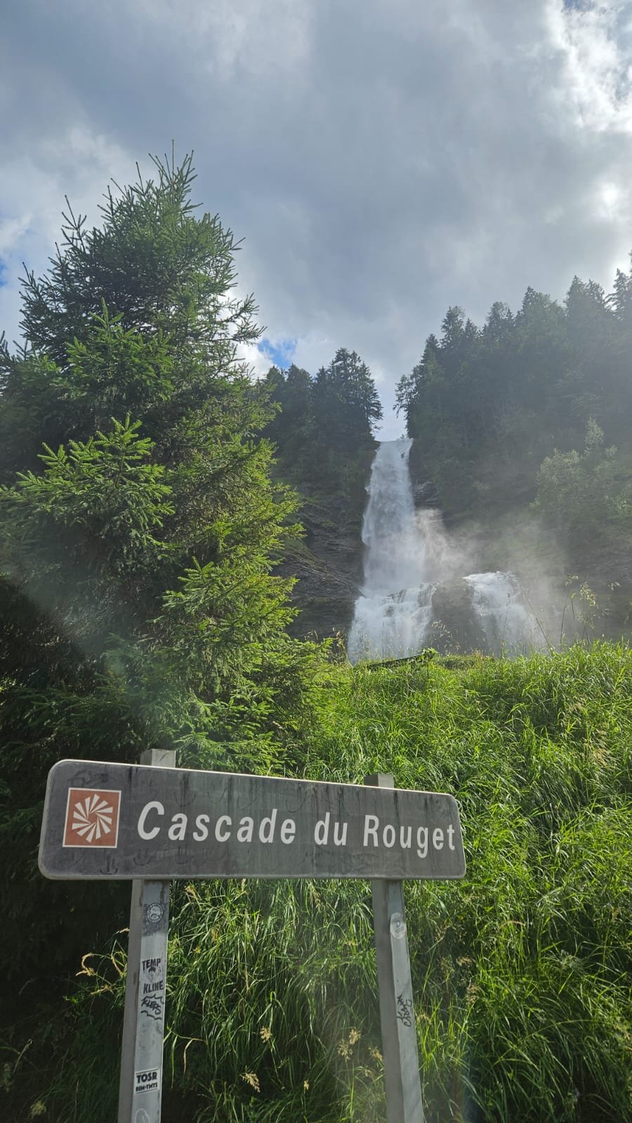 Le panneau « Cascade du Rouget » à l'arrivée, chute en arrière-plan