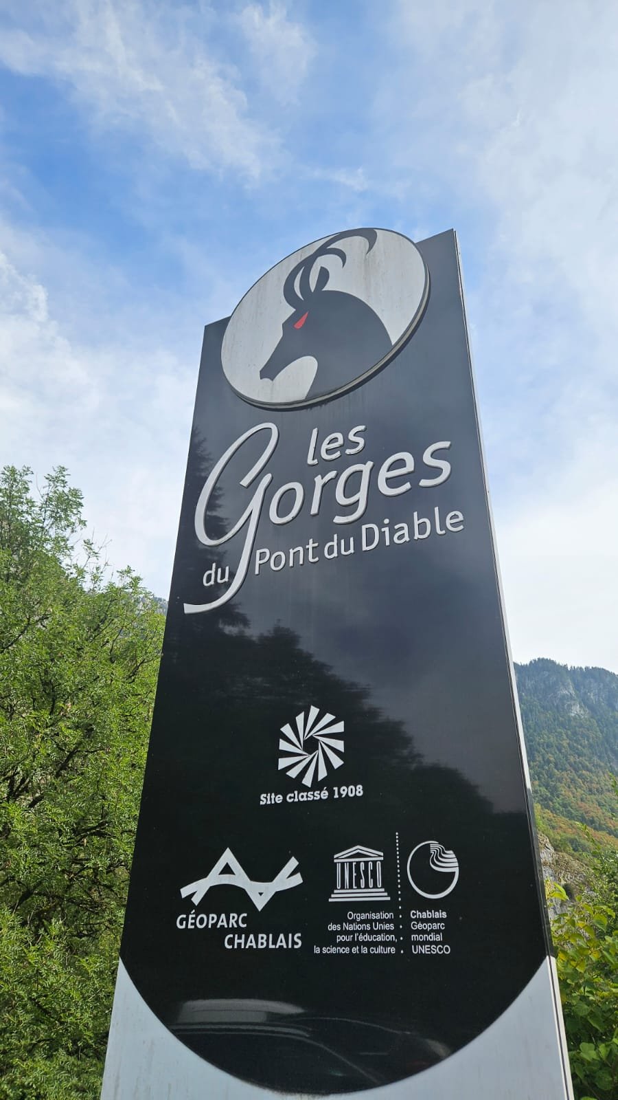 Le panneau d'entrée des Gorges du Pont du Diable, portant « Site classé 1908 », le logo Géoparc Chablais et celui du Géoparc mondial UNESCO