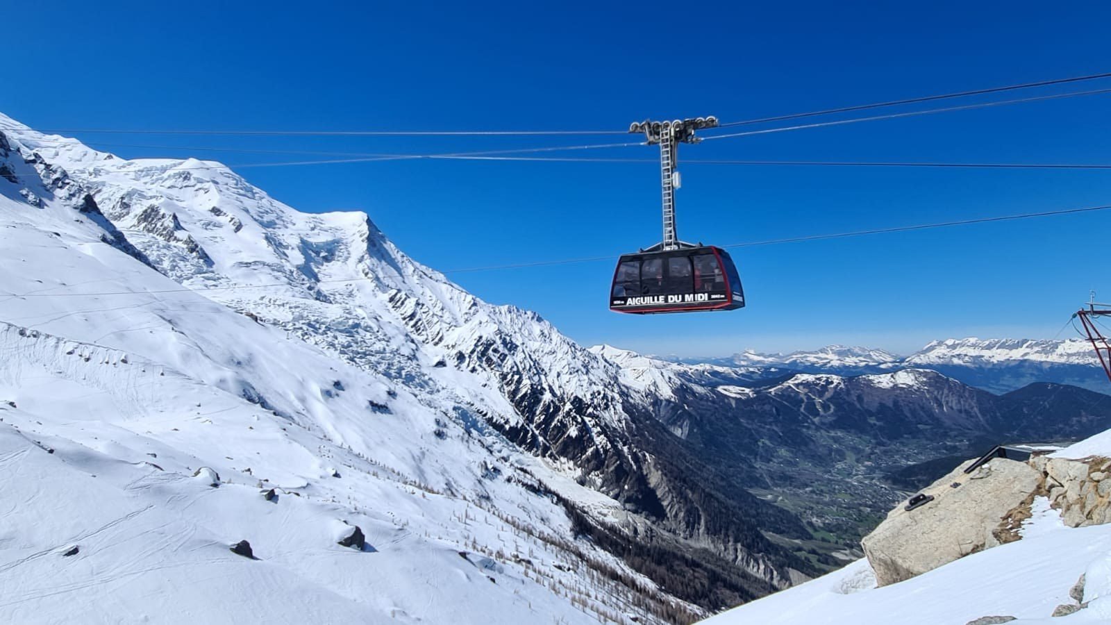 Cabine de l'Aiguille du Midi au-dessus de la vallée de Chamonix, horizon des Aravis