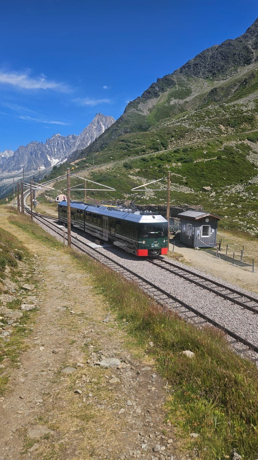 Le Tramway du Mont-Blanc à l'arrêt en alpage face aux Aiguilles de Chamonix