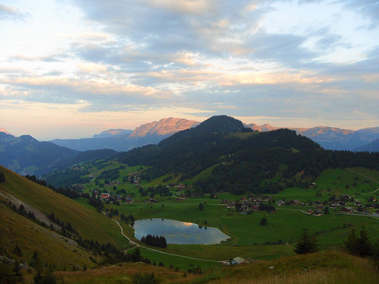 Lac des Confins umgeben von Almen und der Aravis-Kette, La Clusaz, Haute-Savoie
