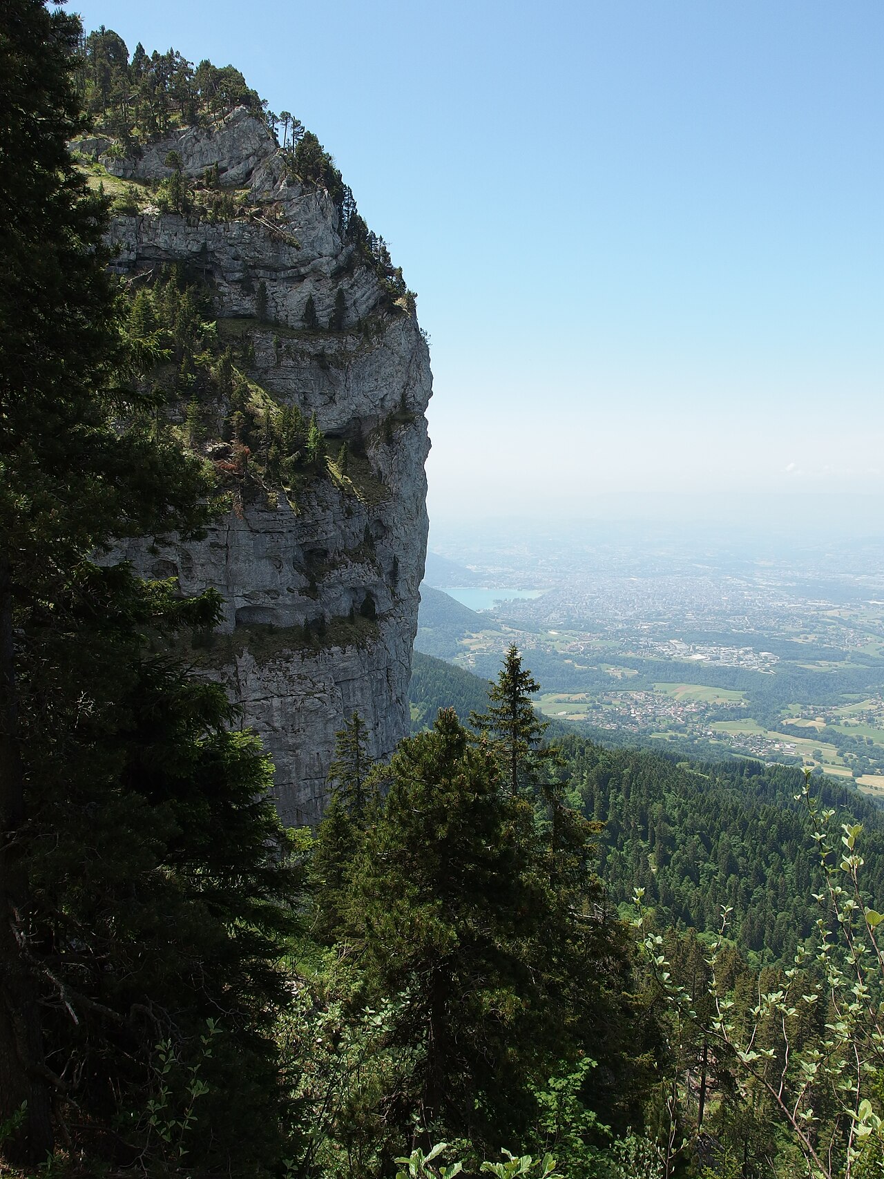 View from Tête du Parmelan with its summit cross and Camille Dunant refuge overlooking Annecy, Bornes massif, Haute-Savoie